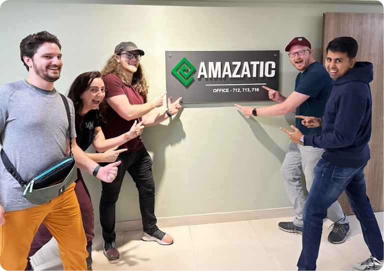 Amazatic team pointing towards name board